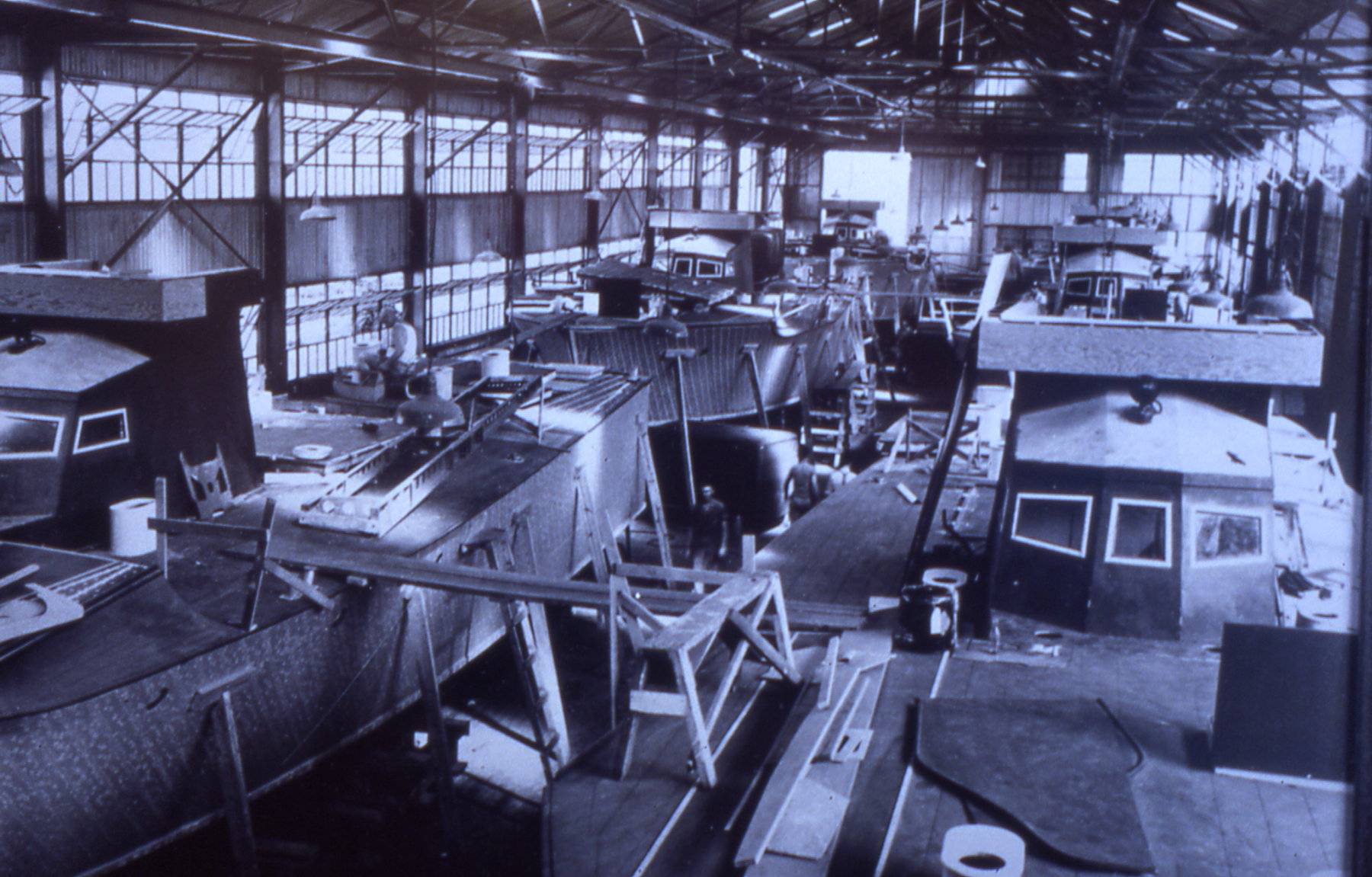 Interior photo of "The Big Shed" circa 1943 as six PT boats are being built for service in World War II at 222 Severn / The Yard.